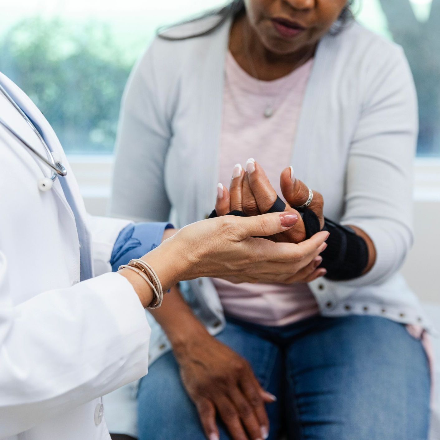 Doctor holding patient's hand with brace