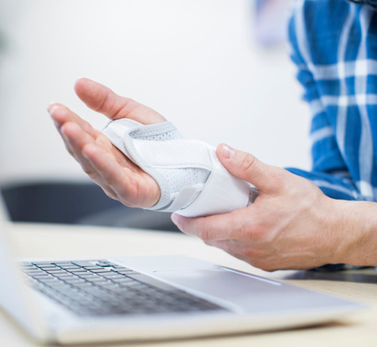 Businessman-using-laptop-suffering-from-repetitive-strain-injury