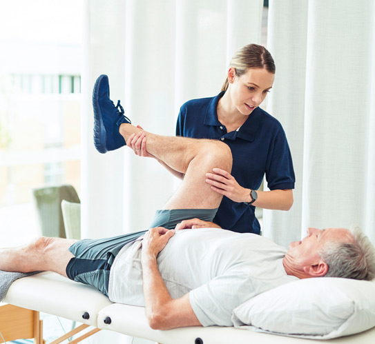 Physiotherapist-helping-elderly-male-for-exercise-therapy