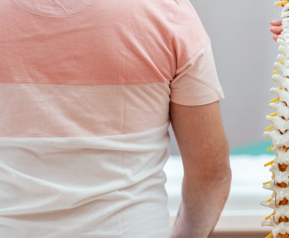 Female-doctor-holding-spine-model